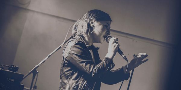 Woman with straight hair holding microphone and singing,