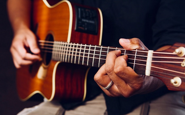 A Person Practicing Chords While Playing Guitar.